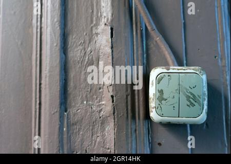 Old Electrical switch on the old weathered wall, old light switch Stock Photo