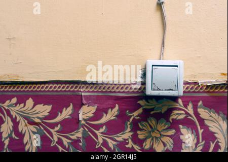 Old Electrical switch on the old weathered wall, old light switch Stock Photo