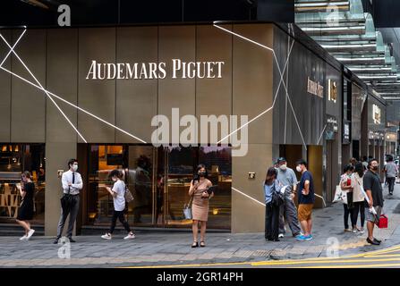 Pedestrians walk past the Swiss manufacturer of luxury watchmaker