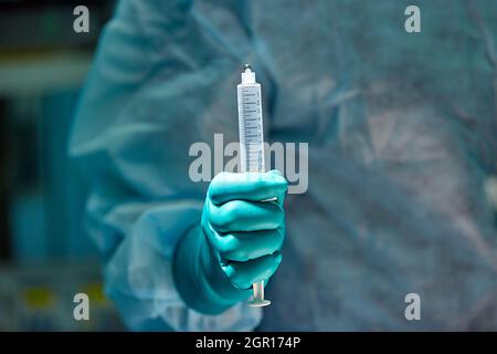 Close up image of doctor's hand holding syringe against patient. Local anesthesia was used before surgery in the hospital. Selective focus on the syri Stock Photo