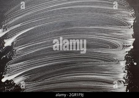 Soap foam on a black table. Foam traces on black background. Copy space. Stock Photo