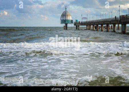 Diving bell at the seabridge in Zinnowitz, tourist resort on the island Usedom at the Baltic Sea in Germany, windy weather with waves and cloudy sky, Stock Photo