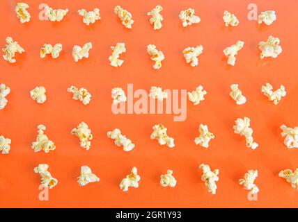 Popcorn on orange background. Movie background. Top view or flat lay. Popcorn on a pastel orange background, top view. Cinema Concept. Flat lay Stock Photo