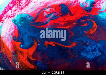 Color ink dissolves in water. Abstract background in red and blue color. Stock Photo