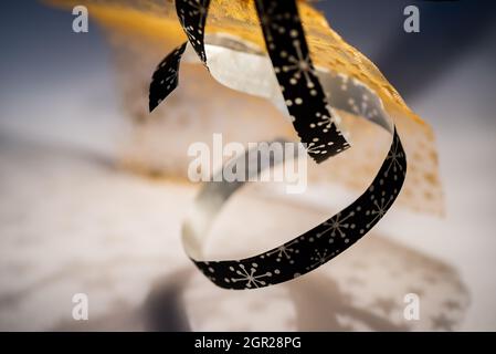Abstract background with twisted decorative ribbon and fabric with golden stars on background with shadow. Stock Photo