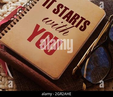 It starts with you text on notebook, glasses and pen. business career concept Stock Photo