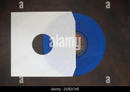 Aged White paper cover and blue vinyl LP record isolated on rusty background Stock Photo