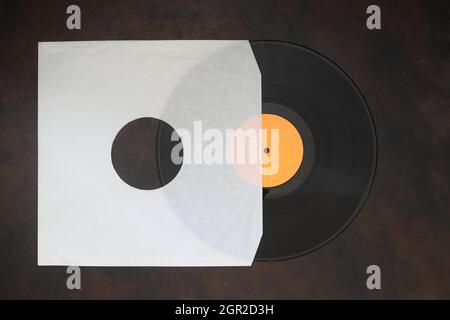 Aged White paper cover and vinyl LP record isolated on rusty background Stock Photo