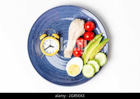 Plate With Vegetables And Alarm Clock On White Background, Intermittent Fasting Concept.