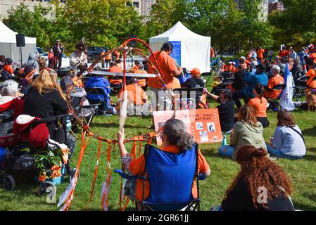 Ottawa, Canada - September 30, 2021: A crowd, including woman with dream catcher, gathers at Confederation Park for event on The National Day for Truth and Reconciliation, aka Orange Shirt Day. The day was proclaimed to be a federal statutory holiday by the Canadian government for the first time in 2021 in light of the revelations of over 1,000 unmarked graves near former residential school sites. Stock Photo