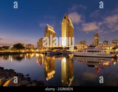 Golden colored Manchester Grand Hyatt Hotel in San Diego reflects in calm marina at dusk Stock Photo