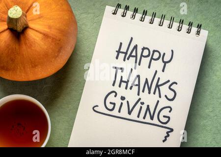 happy thanksgiving greeting card - handwriting in a sketchbook with pumpkin and a cup of tea Stock Photo