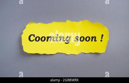 Coming soon on on yellow torn paper, business concept. Stock Photo
