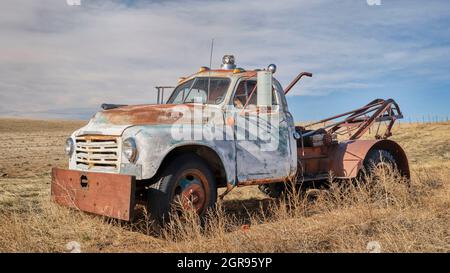 old rusty towing truck on a prairie, early spring scenery in Colorado Stock Photo