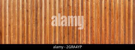 Brown, honey-colored panoramic wooden wall made of vertical, grained boards Stock Photo