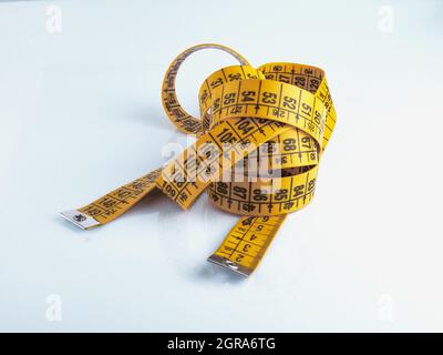 Yellow measuring tape isolated on white background. Stock Photo