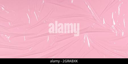 Crumpled wrinkled plastic transparent plastic cellophane on light pink color background. Abstract creative texture background Stock Photo