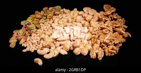 Nuts mix of pistachios, pine nuts, cashew nuts, on dark background Stock Photo