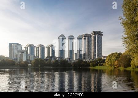 Moscow, Russia - 21 September 2021, Round multi-storey buildings are reflected in a small pond near the Minskaya metro station Stock Photo