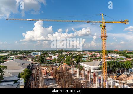 A crane in large construction site, Crane working on a building complex with cloud and blue sky. Stock Photo