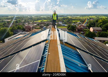 Asian engineer checking equipment in solar power plant on roof. clean energy Stock Photo