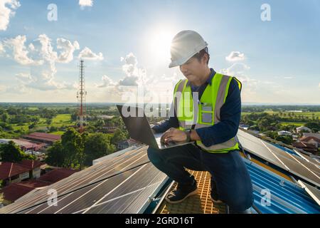 An engineering  working on checking and maintenance in solar power plant on the roof, Solar power plant to innovation of green energy for life. Stock Photo