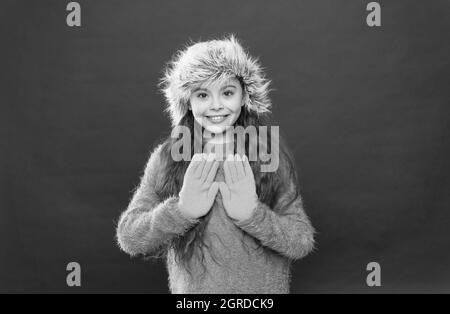 happy teen girl wear warm clothes. feel comfortable and cozy in any weather. winter holiday and vacation. kid in hat with ear flaps. child in knitted Stock Photo