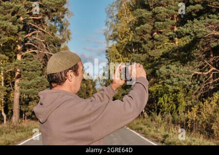 Senior Muslim asian man shooting video for his blog on mobile phone Stock Photo