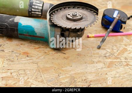 Worker hand holding angle grinder with diamond cutting disc for concrete ready to saw a cement slab. Cutting metal angle grinder, sparks from the disk Stock Photo