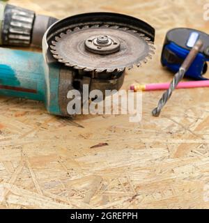 Worker hand holding angle grinder with diamond cutting disc for concrete ready to saw a cement slab. Cutting metal angle grinder, sparks from the disk Stock Photo