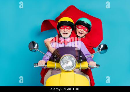 Photo of retired pensioner grey haired couple wife husband people wear helmet mask ride biker isolated on blue color background Stock Photo