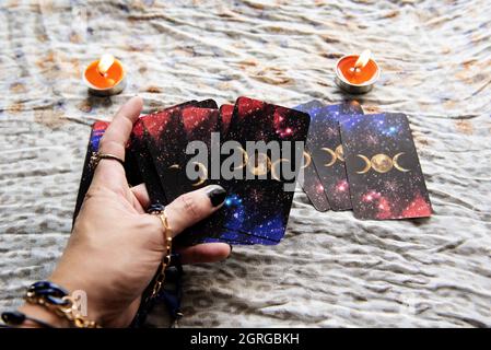 Show fortune tellers of hands holding tarot cards and tarot reader with candle light on the table, Performing readings magical performances, Things my Stock Photo