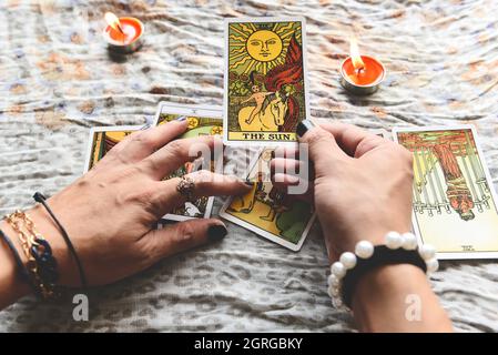 Show fortune tellers of hands holding tarot cards and tarot reader with candle light on the table, Performing readings magical performances, Things my Stock Photo