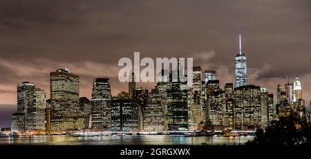 View of Lower Manhattan, the World Trade One building and the surrounding Brooklyn Bridge, as seen from Brooklyn, near the D.U.M.B.O. Stock Photo