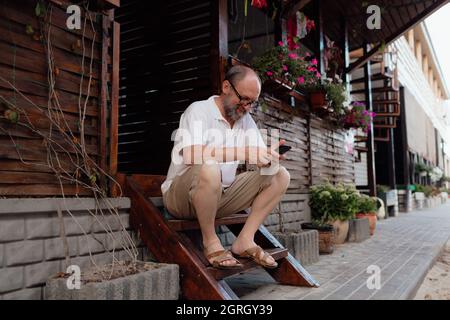 Funny old man he talks on the phone . Summer holiday Stock Photo