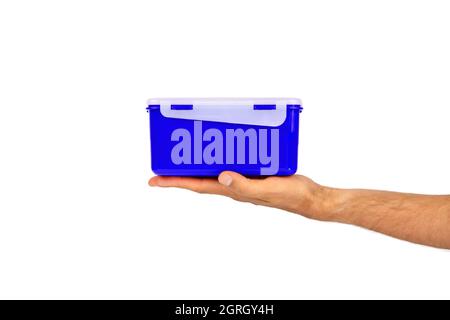 In a man's hand made of eco plastic of the current color, a lunch box for a quick and pleasant lunch, breakfast and dinner. With place for text. Stock Photo