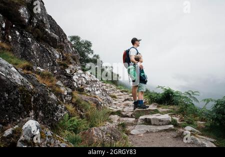 father and son climbing Ben Nevis mountain range in the UK Stock Photo