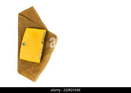 Rectangular piece of moldy cheese on craft paper. Top vew. Stock Photo