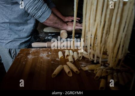 Man rolling out dough by hand for home made pasta Stock Photo
