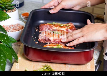 Raw marbled beef steak slices with salt and spices on metal baking dish for oven background. The preparation of a fresh meat for dinner. Stock Photo