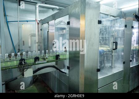 Beverage bottling room with automatic machinery and control panel in production line at beverage processing factory Stock Photo