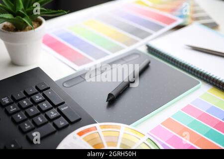 Graphic tablet stylus and color palette on table Stock Photo