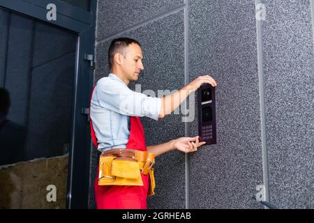 Builder installing an intercom. renovation in a renovated building Stock Photo