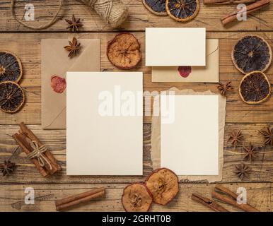 Winter Christmas Composition with a blank cards and envelope over wooden table flat lay. Christmas and New Year greeting card template with dried frui Stock Photo