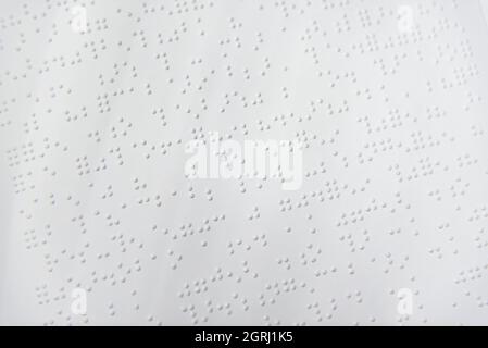 A fragment of text in Louis Braille printed on a standard sheet of paper using special printing equipment. Stock Photo