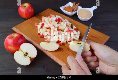 Man's hand cutting fresh apples with knife for making apple compote Stock Photo