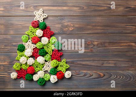 Christmas tree made from colored handmade ball decoration on colored background, view from above. New Year minimal concept with copy space. Stock Photo