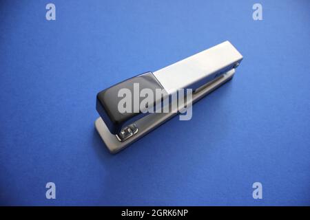stapler on blue background in natural light Stock Photo