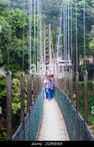 KANDY, SRI LANKA - JULY 18, 2016: People at a suspension foot bridge in Peradeniya Royal Botanical Gardens near Kandy, Sri Lanka Stock Photo