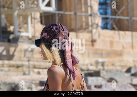 beautiful girl , with a headscarf on her head, posing in front of the Acropolis Parthenon Stock Photo